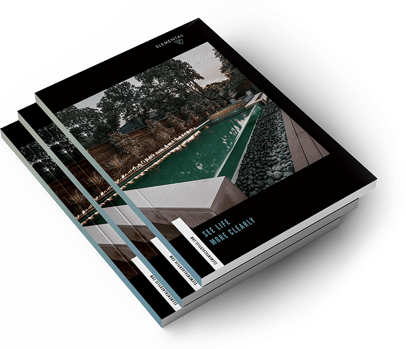 Three stacked magazines feature a cover image of a modern outdoor pool surrounded by decking, landscaping, and trees. The cover text says, “SEE LIFE MORE CLEARLY.”.